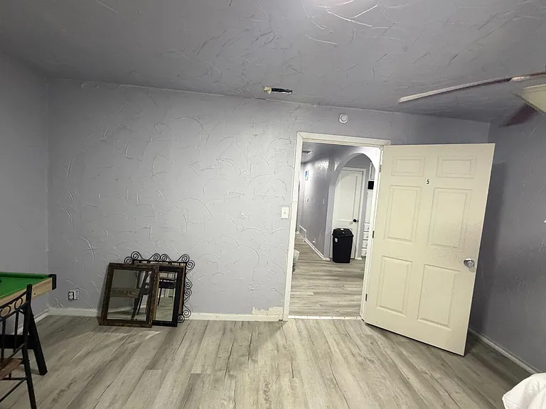 Private bedroom with durable plank-style flooring and direct access to the hallway, offering a flexible layout for furnishing