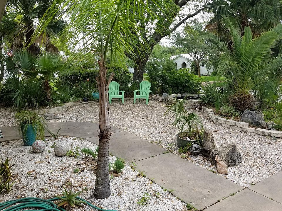 Front Courtyard with Coquina Shell sitting area and fountain Fenced in BACK YARD with patio not shown. Second great sitting area.