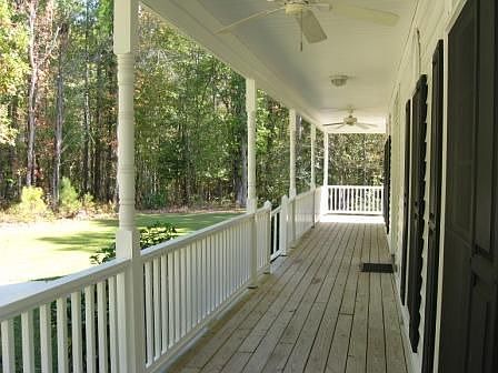 Covered rocking chair front porch with ceiling fans. 