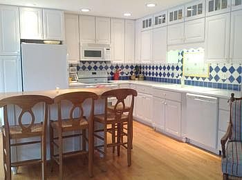 Beautiful white cabinets & corian countertops enhance this grand kitchen with all the major applianc