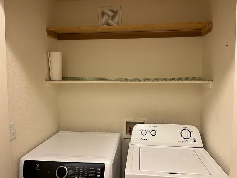 Laundry area with storage shelves.