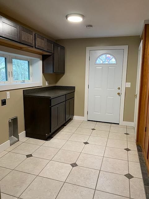 Laundry room off kitchen with door to back parking and back yard. Basement door is on the right. There is also a laundry closet with a drop down iron board and a broom closet . The laundry room is set up for both a gas or electric dryer. Tile floor, new c
