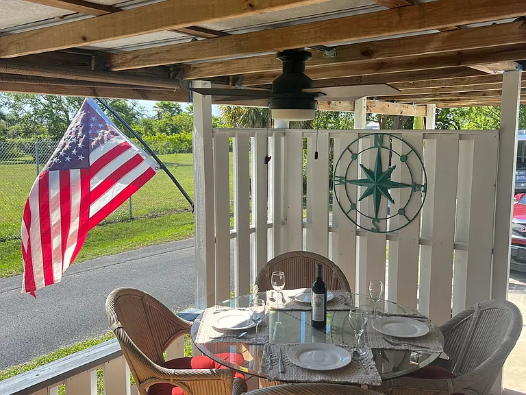 Outdoor dining under the covered deck. A nice view to open green space and daily sunsets.