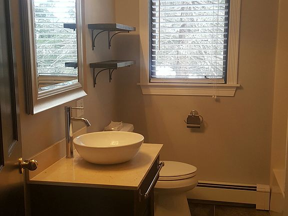 updated bathroom, new vanity and porcelain floors, linen cl