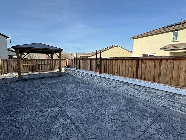 New Backyard with stamped concrete and retaining wall with lights