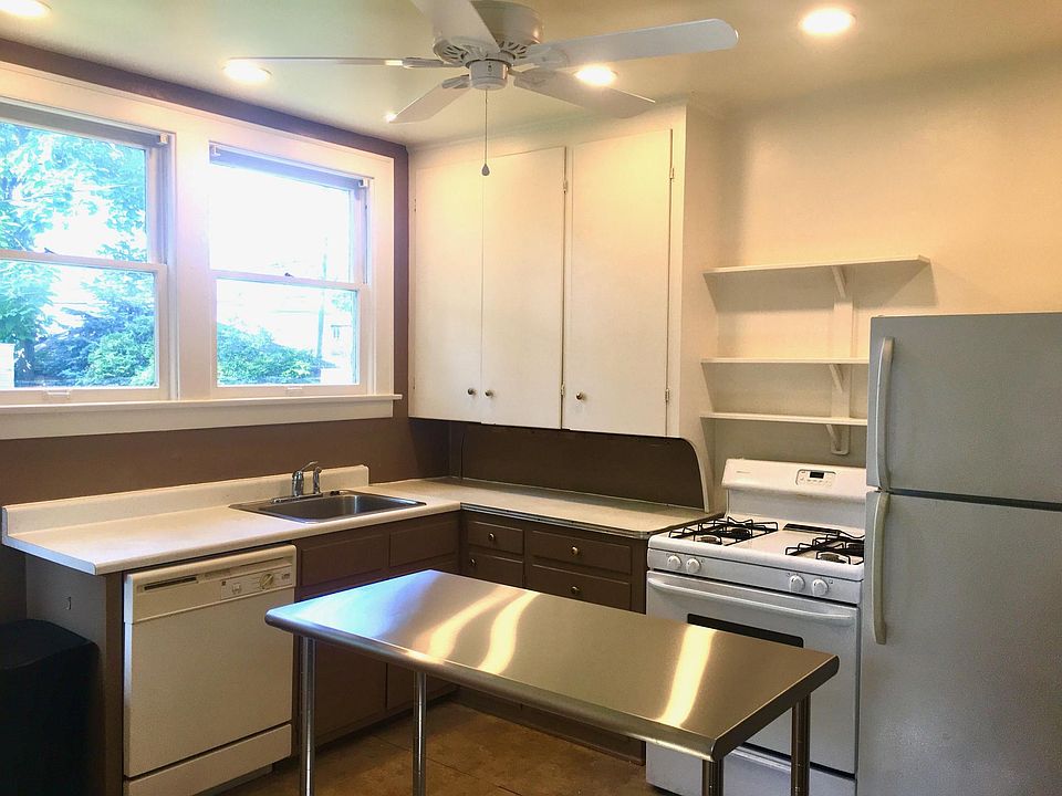 Kitchen supplied with dishwasher, fridge, stove, in-sink garbage disposal, and stainless steel island table.