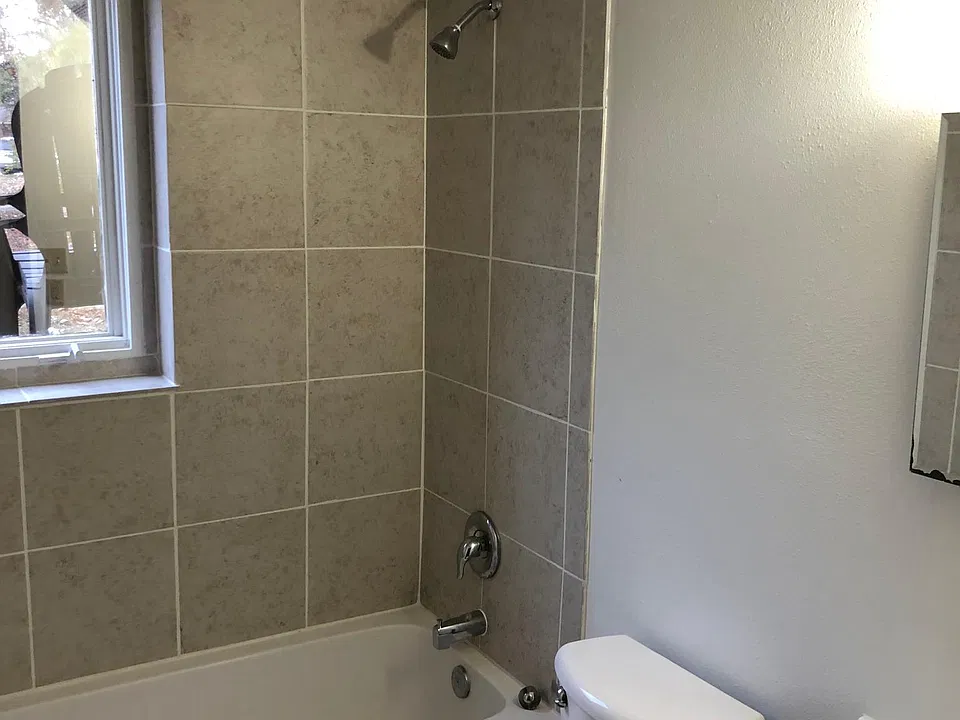 Bathroom with new tub, tile surround for tub and flooring