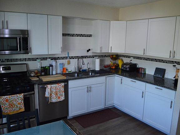cabinets with tile backsplash and stainless appliances