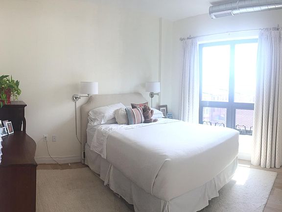 South-facing bedroom with hardwood floors and operable windo