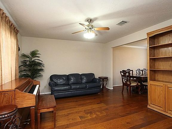 The formal living room has hickory wood flooring and is just off the entry foyer.