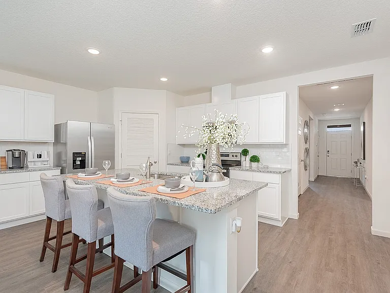 Bright and modern kitchen featuring sleek granite countertops, stainless steel appliances, and inviting breakfast bar with stylish seating.