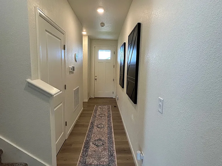 Hallway looking at the entrance and stairs to upstairs on left.