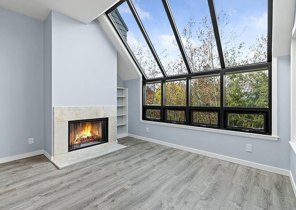 light-filled living room w/fireplace, vaulted ceilings w/skylights.