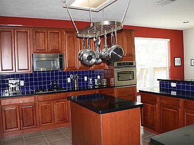 Gorgeous kitchen with granite, beautiful cabinets and a dash of color on the backsplash!