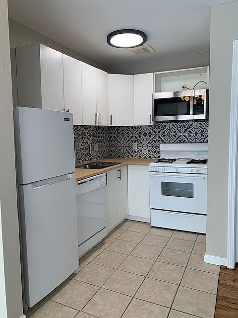 Kitchen features: built-in microwave, gas stove, tile backsplash, dishwasher, refrigerator