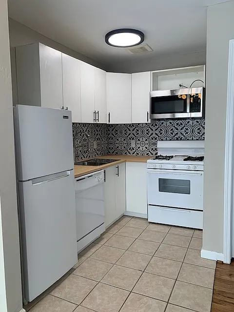 Kitchen features: built-in microwave, gas stove, tile backsplash, dishwasher, refrigerator - 3001 Helena St #6