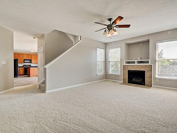 Family room features gas fireplace, built-in area for TV and ceiling fan.