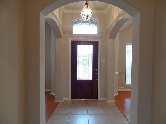 Lovely lead glass front door welcomes guests. The foyer has high ceiling with crown molding, ceramic