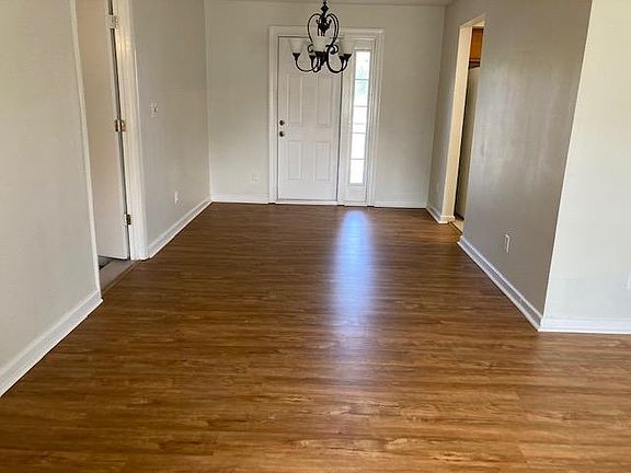 New Flooring. Looking from livingroom to diningroom. Back door leads to outside deck.
