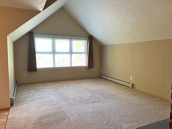 Vaulted living room with large windows including 2 inch blinds and black-out window curtains