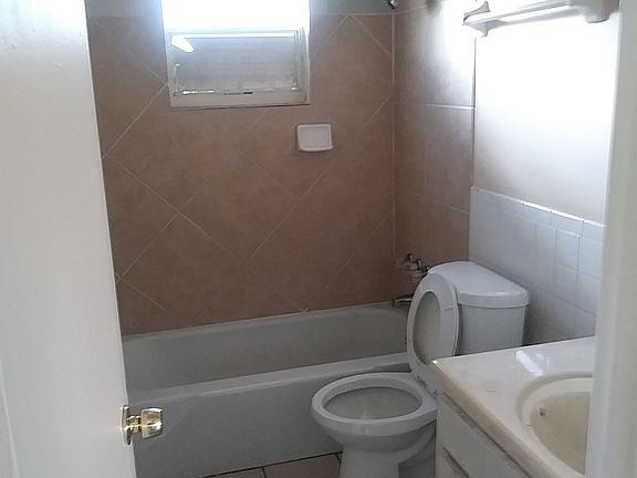 Bathroom with tile walls and bathtub.