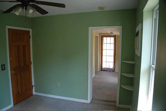 Looking from living room toward bedroom. The door on the left is a second exit to a stairwell.