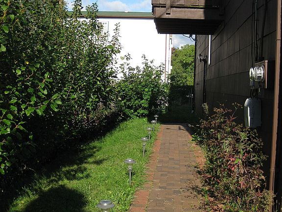 Left Side: Paved and lit walkway leads to In-Law suite door and fenced yard