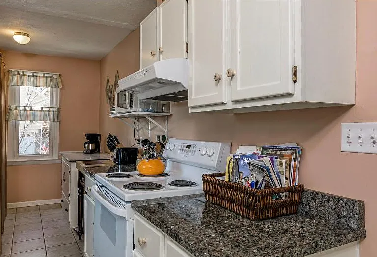 A chef's delight kitchen with beautiful granite countertops and washer dryer at the back