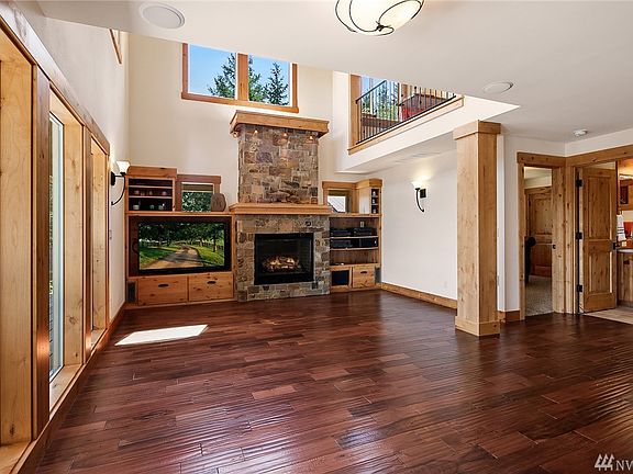 Sun-drenched 2 story great room features hand scraped Brazilian Cherry floors, stone fireplace & built in cabinetry.