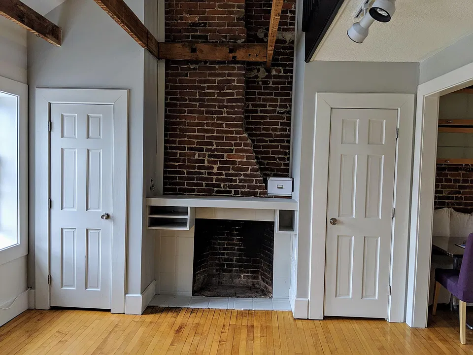 Living room, custom mantle for TV, entertainment, flanked by closets.