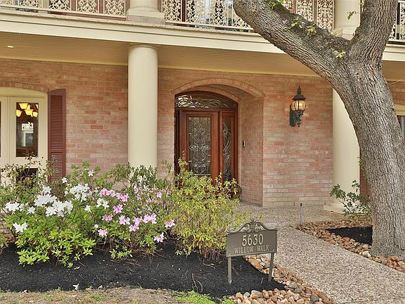 Columns and azaleas flank the beautiful leaded glass front door.