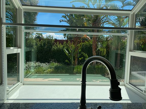 View from the kitchen window. A sizable backyard in which to entertain, relax and play. Easy access to community pool from back yard gate.