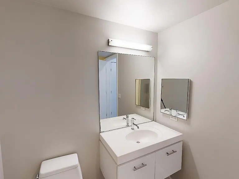 Apartment bathroom with wood-style flooring.