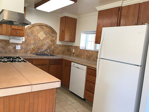 kitchen with garbage disposal, fridge, gas stove, dishwasher and large pantry.