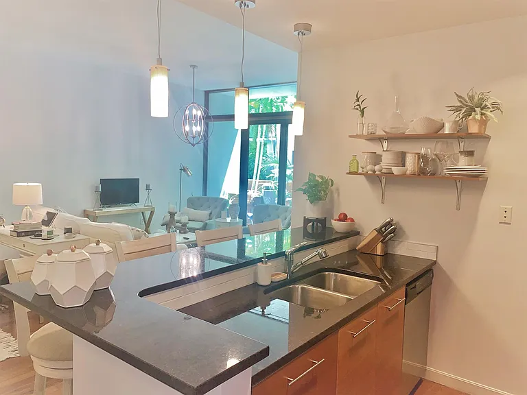 Kitchen features stainless steel appliances, new garbage disposal. Open shelving for storage