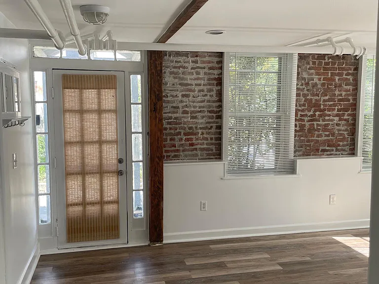 Entrance door with historic beam and exposed brick walls.