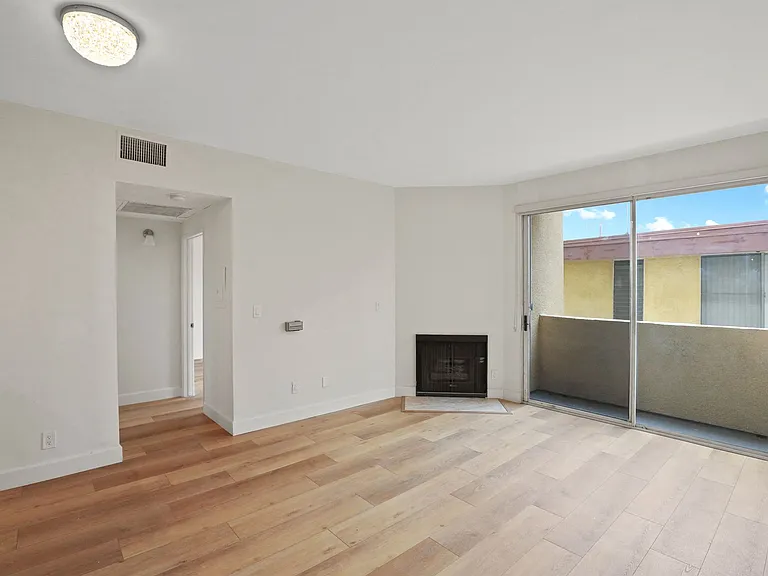 Living Room with an Electric Fireplace, Vinyl Flooring, and Balcony