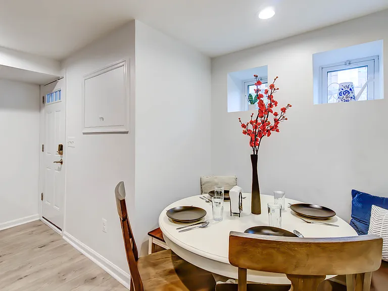 The cozy breakfast nook sits beneath two garden-facing windows, creating the perfect spot to enjoy meals with a touch of natural light.