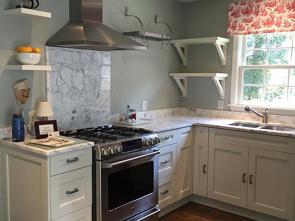 Newly renovated kitchen with marble counters and stainless steel appliances.