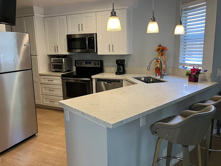 Kitchen with Marble countertops and hardwood floors and all appliances