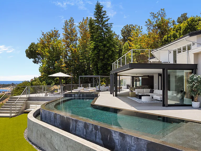 The living room seamlessly transitions to the poolside, offering direct access and stunning views.