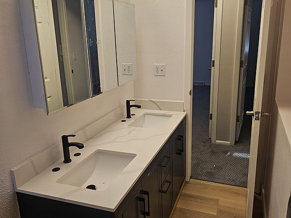 Upstairs bath with fresh update including double vanity, medicine cabinets and light fixture.