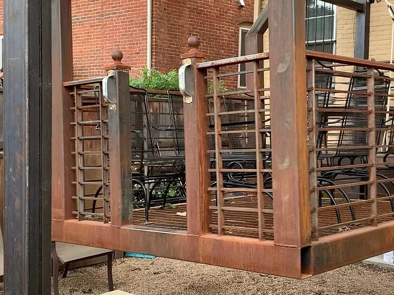 Hanging swing in backyard with dog area below.