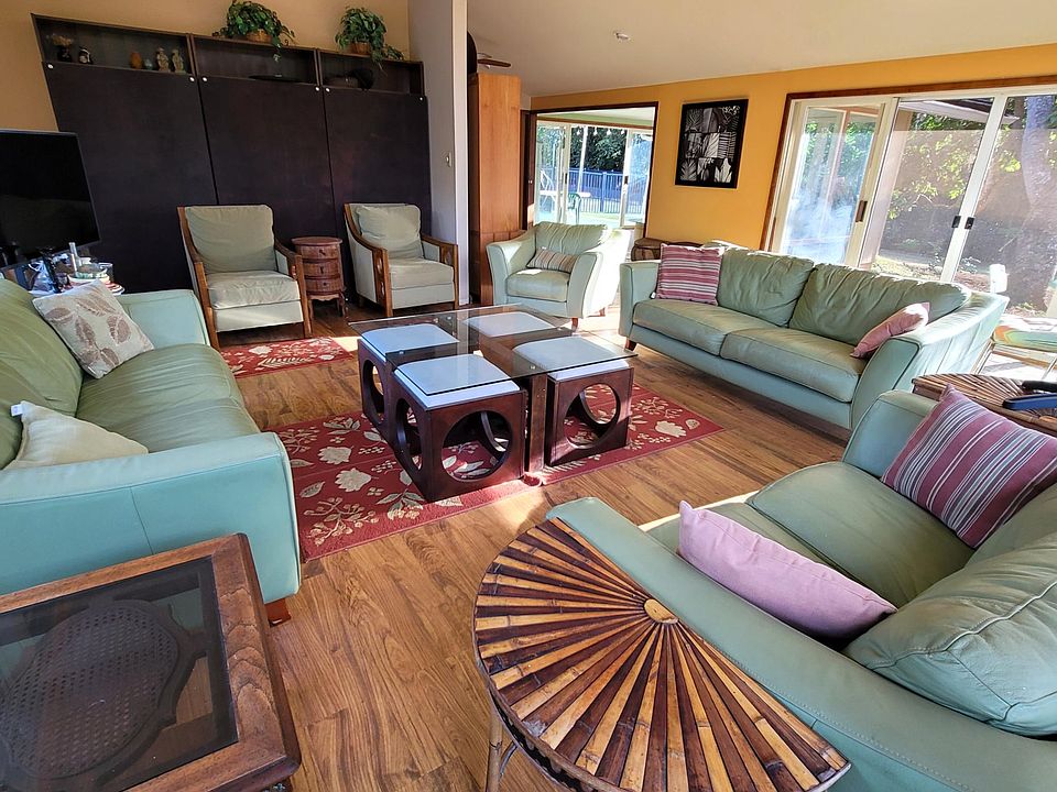 Living room with view of back yard, pool and courtyard. Sliding glass doors, with screens, open to the back yard.