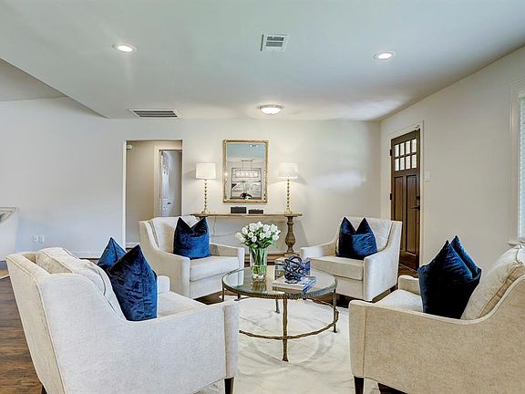 Light from the huge window in the formal living floods the space and note the recess cans the custom window coverings and room for an accent piece in the foyer