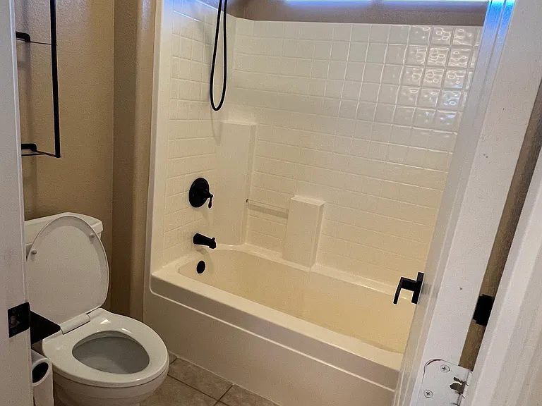 upstairs bathroom toilet, tub, shower room with handheld facuet, towel storage rack and shelf, wall hooks, double towel rack, double toilet roll holder with phone shelf