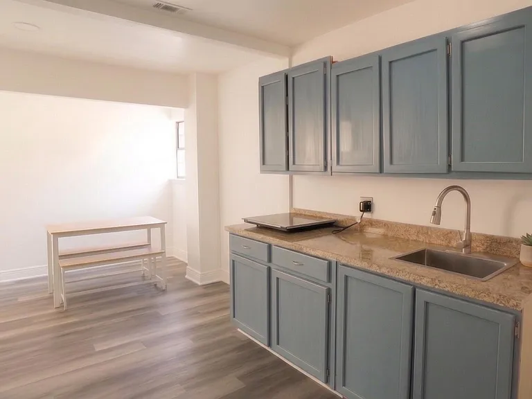 Kitchen with ample cabinet storage, laminate counters, stainless sink, and an adjacent nook for a small dining setup.