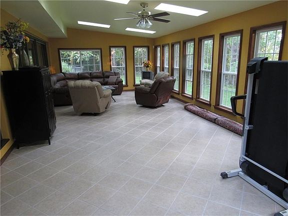 3/4 season room off the back of the home with newer neutral tiled flooring.