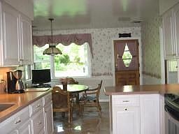 Large eat in area with picture window and dutch door entrance to rear covered 