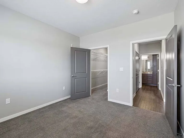 A peaceful bedroom retreat offers soft natural light, plush carpeting, and a comfortable place to unwind at the end of the day.